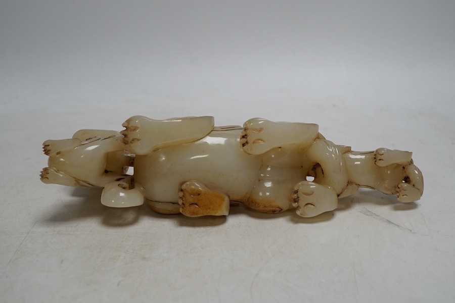 A Chinese archaistic white and russet jade lion-dog group, 20cm long. Condition - good